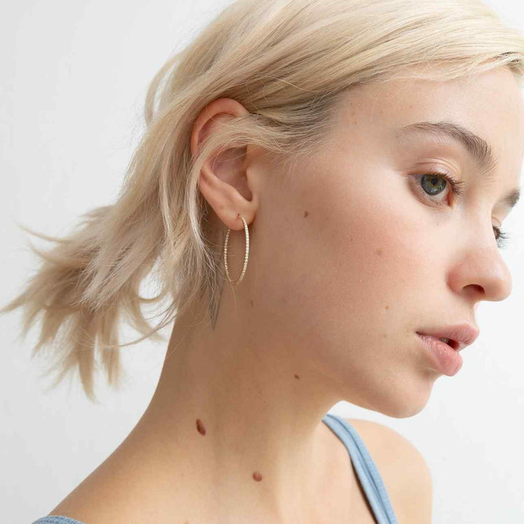An inside-out diamond hoop with round brilliants that line the interior and exterior of this earring This earring is meant for stacking in any combination - shown in Yellow Gold here.
