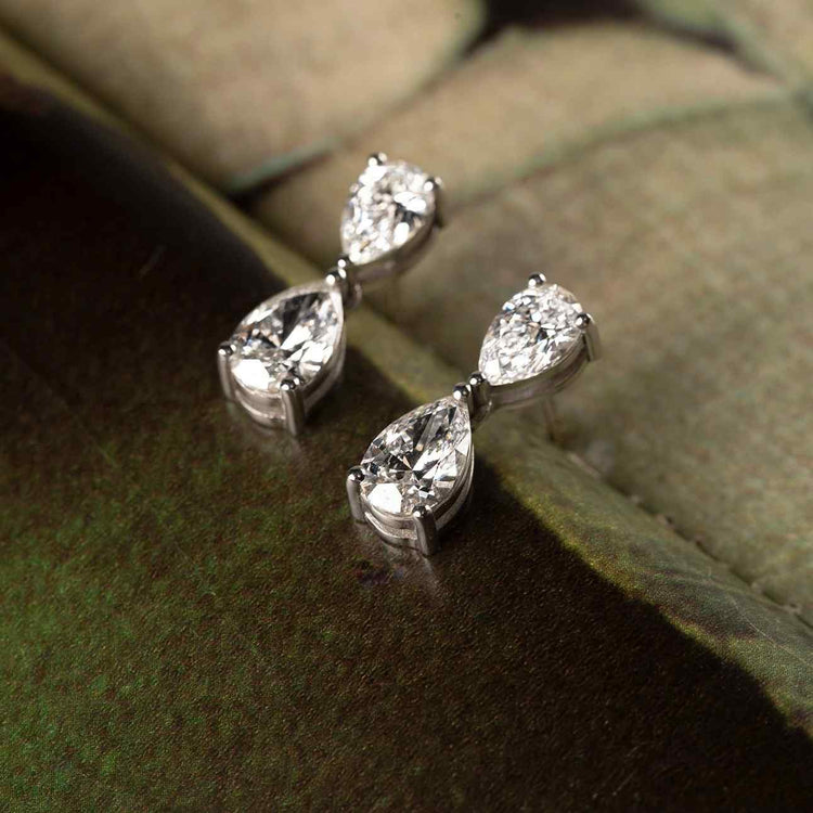 The Bisous de Poires earrings feature two pear diamonds turned towards one another in what resembles a kiss. The pair of earrings is 4.3 total carat weight - 2.15 tcw on each ear - with four D color, IF/VVS clarity diamonds. Shape, color, and size of the pear diamonds are fully customizable. Shown in White Gold here.