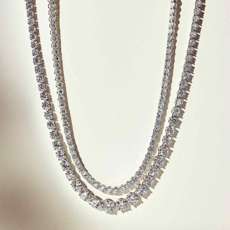 The Collier de Diamants necklace (15 total carat weight) shown hanging next to the Collier Rivière Tennis Necklace (25 total carat weight).