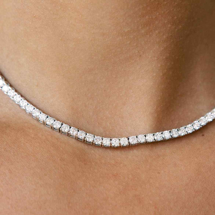 Model wears our diamond tennis necklace - which features round brilliants in a four prong solitaire setting. Diamonds wrap the entire length of this 16-inch (40cm) necklace in 18K White Gold. 15tcw necklace is shown in photos.