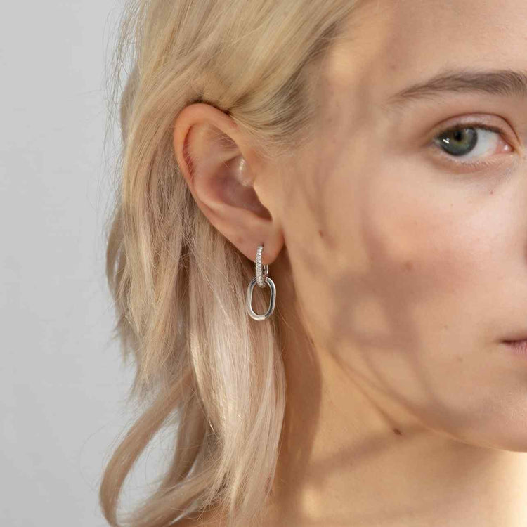 A model showcases the Ecluse earring with the top diamond link made of pavé diamonds - which sparkle brilliantly in the sun. Earrings are sold as a pair, with complementary diamond / gold links. White Gold shown here. Reach out to our team for customization options.