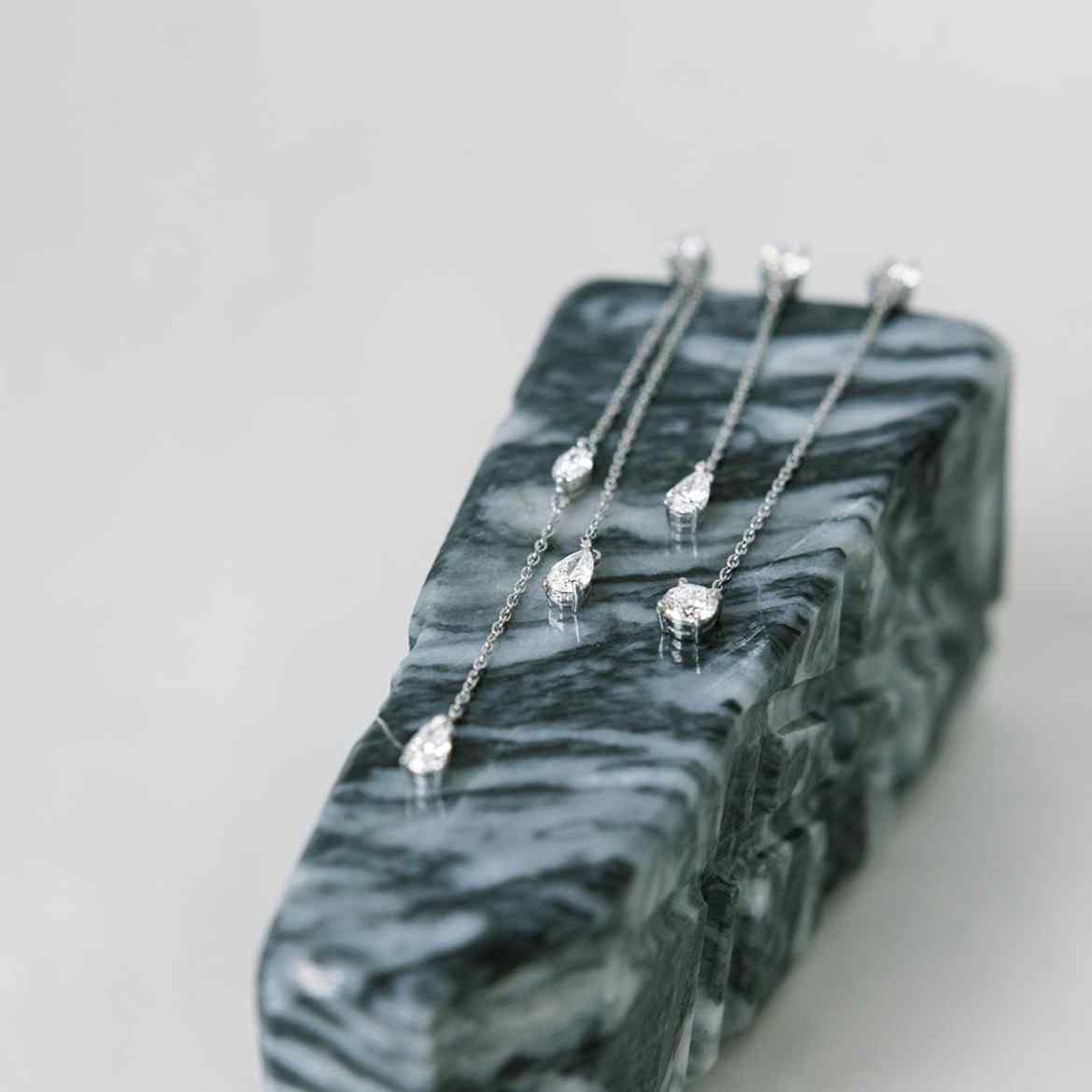 The Lariat Trois earrings shown here with a custom jacket (or additional chain with a diamond) that attached through the stud. Also shown with the Lariat Deux. All D color, IF/VVS clarity diamonds.