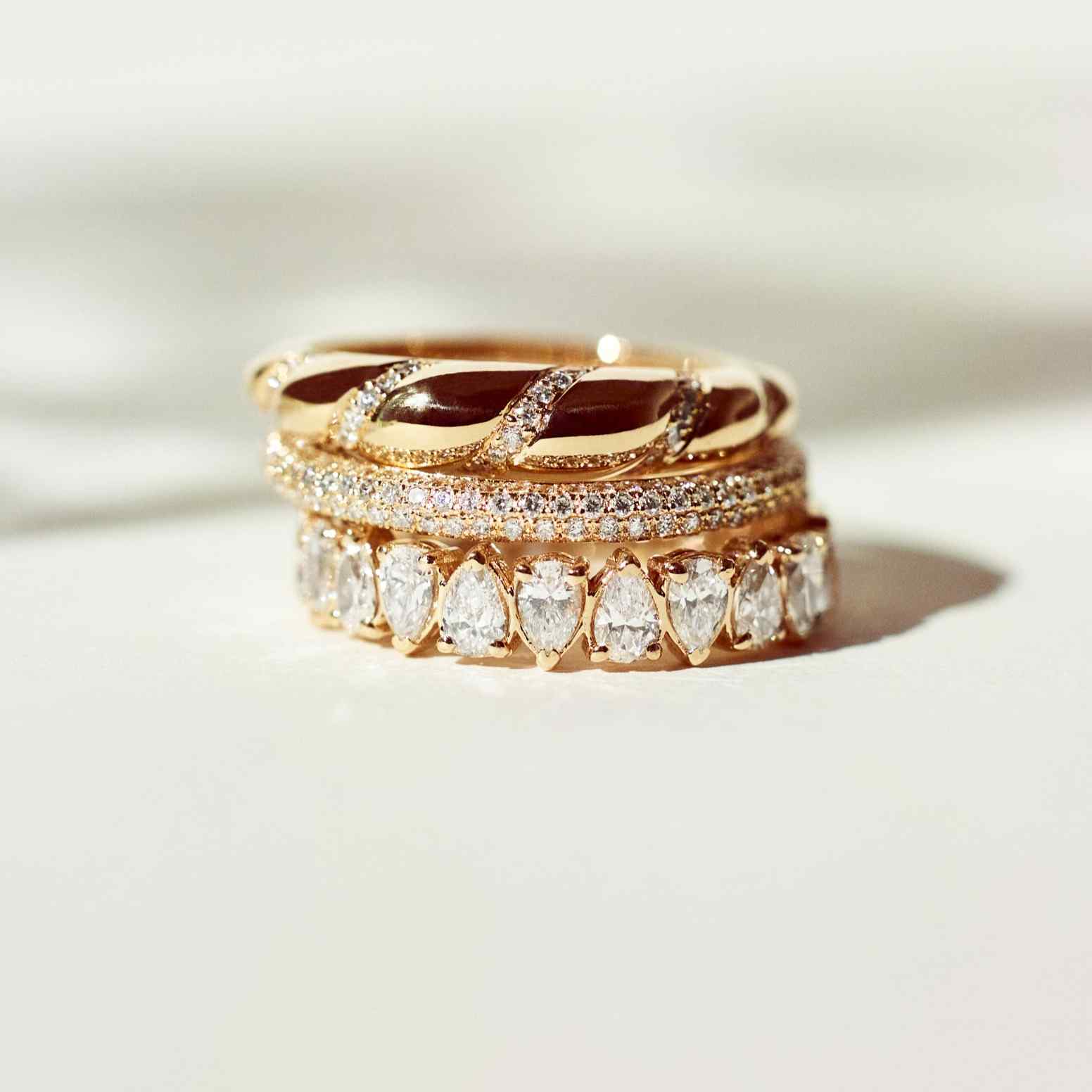 Shown here - an unrivaled stack of three rings. The Lune ring was designed to stack with rings from the Dalliance and Sans Cesse collections for a perfect warm gold pairing. The Lune ring features 6 grams of voluminous 18K Yellow Gold with diamonds woven throughout. All diamonds are D color, IF/VVS clarity.