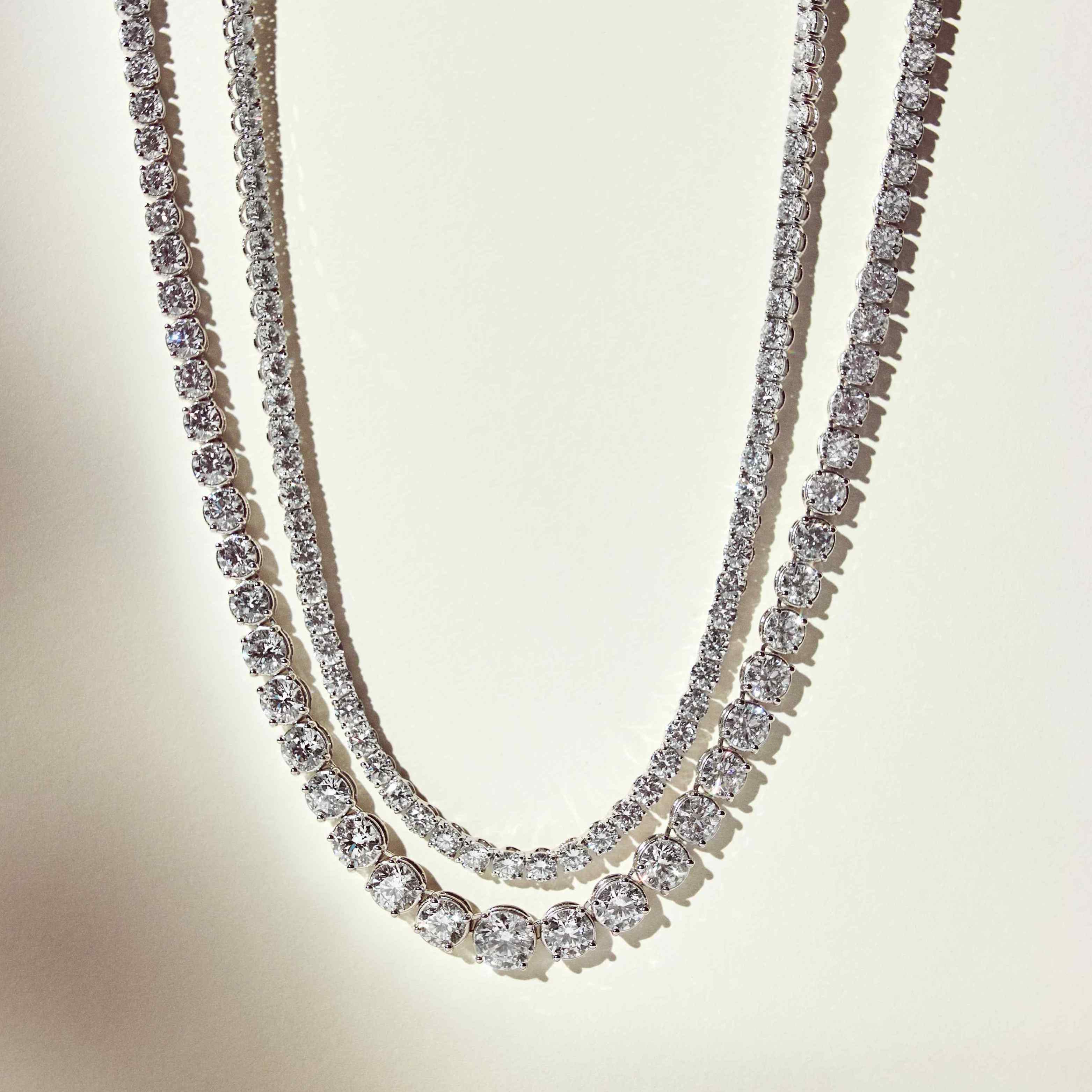 The Collier Rivière is a 25ct graduated diamond tennis necklace that features flawless round brilliants in a four prong solitaire setting. Paired here with the Collier de Diamants - our uniform tennis necklace, for the ultimate stack. D-color, IF/VVS diamonds crescendo toward a center diamond of 1ct. The length of this striking piece is 16 inches (40cm).