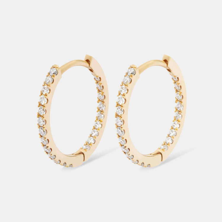 An inside-out diamond hoop with round brilliants that line the interior and exterior of this earring. This 12mm hoop is meant for stacking in any combination - shown in Yellow Gold here.