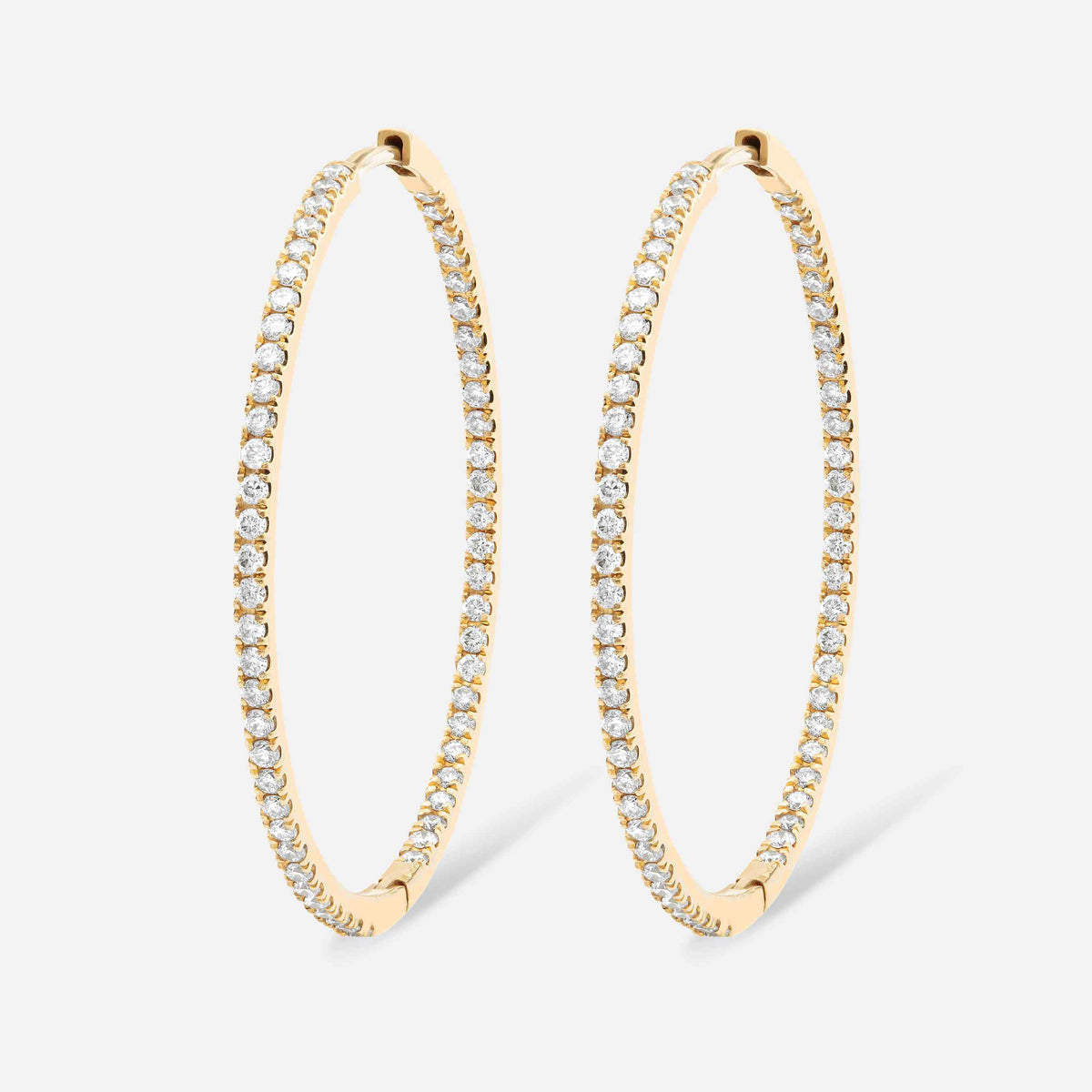 An inside-out diamond hoop with round brilliants that line the interior and exterior of this earring. This 30mm hoop is meant for stacking in any combination - shown in Yellow Gold here. 