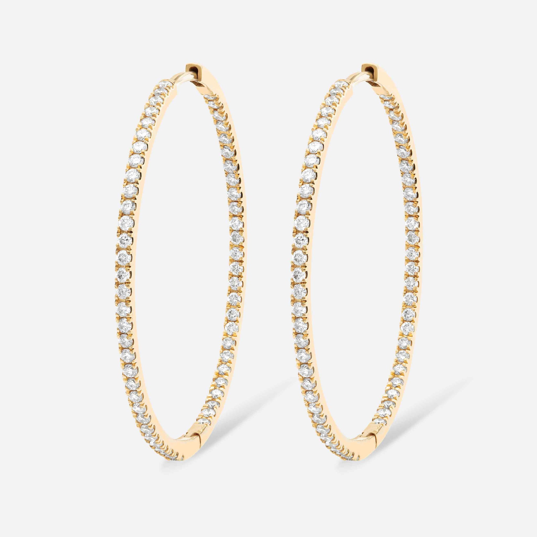 An inside-out diamond hoop with round brilliants that line the interior and exterior of this earring. This 30mm hoop is meant for stacking in any combination - shown in Yellow Gold here. 