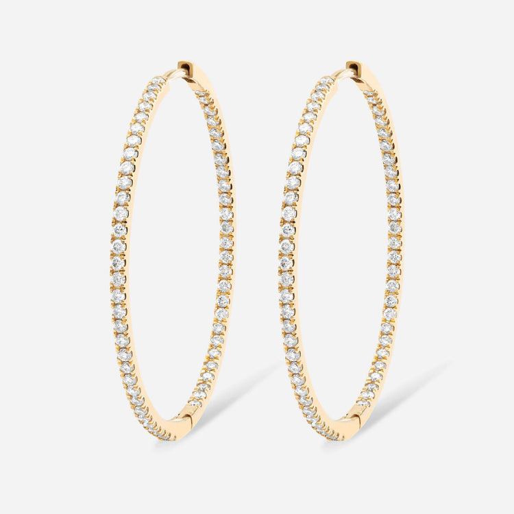 An inside-out diamond hoop with round brilliants that line the interior and exterior of this earring. This 30mm hoop is meant for stacking in any combination - shown in Yellow Gold here. 