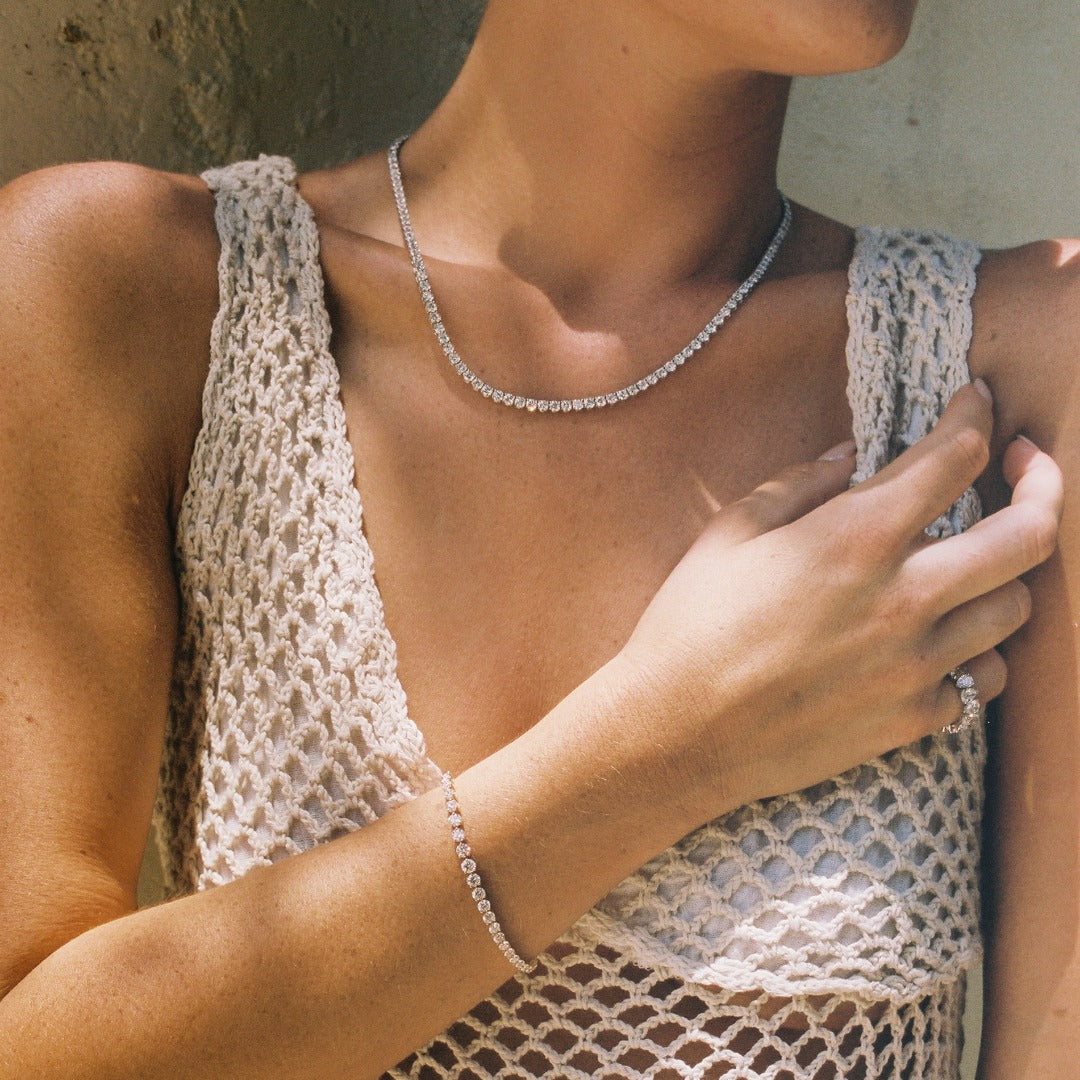 The Collier de Diamants Tennis Necklace paired with the Bracelet George Rivière and Sans Cesse Pear Eternity Ring, elevating this chic crochet summer dress. All pieces feature D color, IF/VVS clarity diamonds.