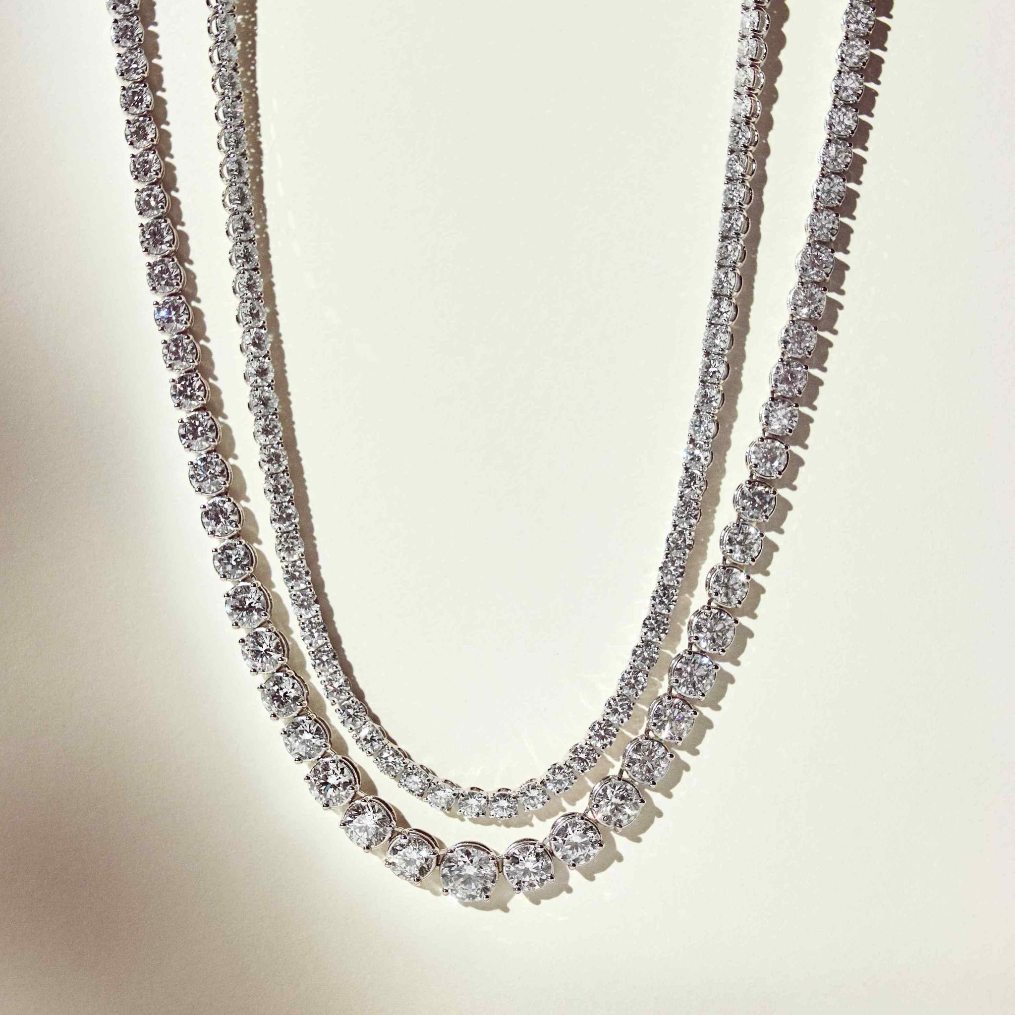 This 25ct graduated diamond tennis necklace features flawless round brilliants in a four prong solitaire setting. Paired here with the Collier de Diamants - our uniform tennis necklace, for the ultimate stack. D-color, IF/VVS diamonds crescendo toward a center diamond of 1ct. The length of this striking piece is 16 inches (40cm).