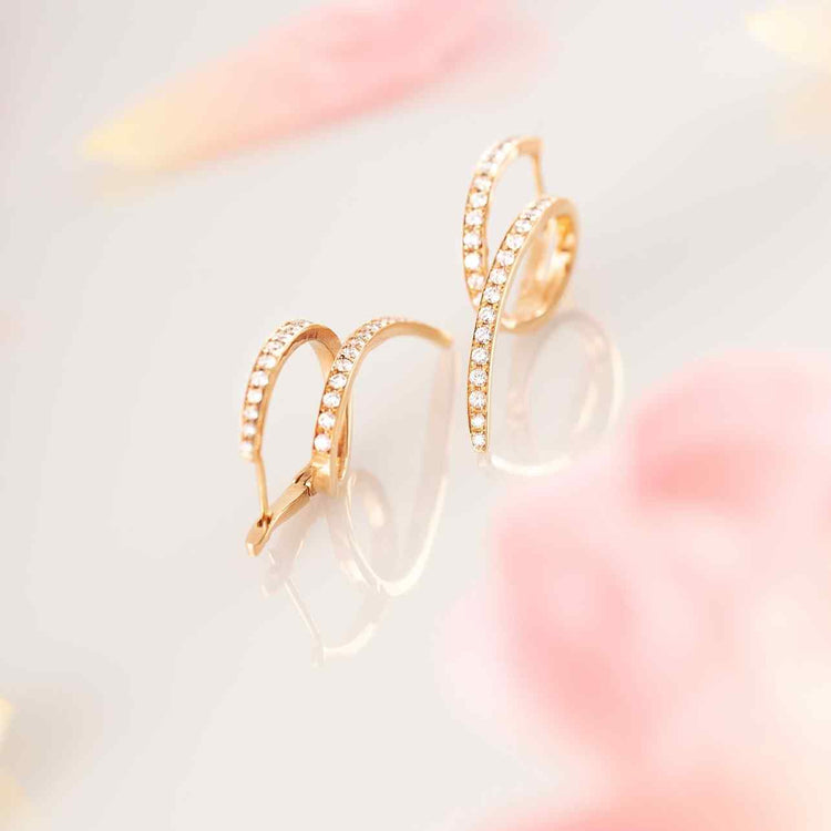 These unique earrings feature 62 diamonds in a twist design with 6.25 grams of 18k recycled gold. Sold as a pair.