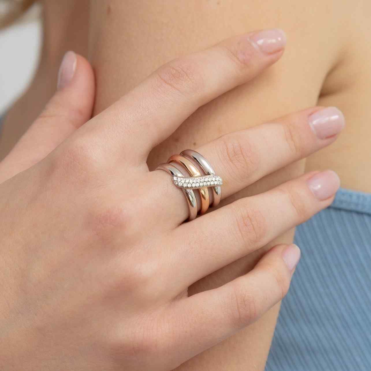 A model wears the Dalliance Sash Ring - made with recycled 18K White and Rose Gold - mixing cool and warm tones for the perfect statement ring. The sash of pavé diamonds are all D color, IF/VVS clarity.