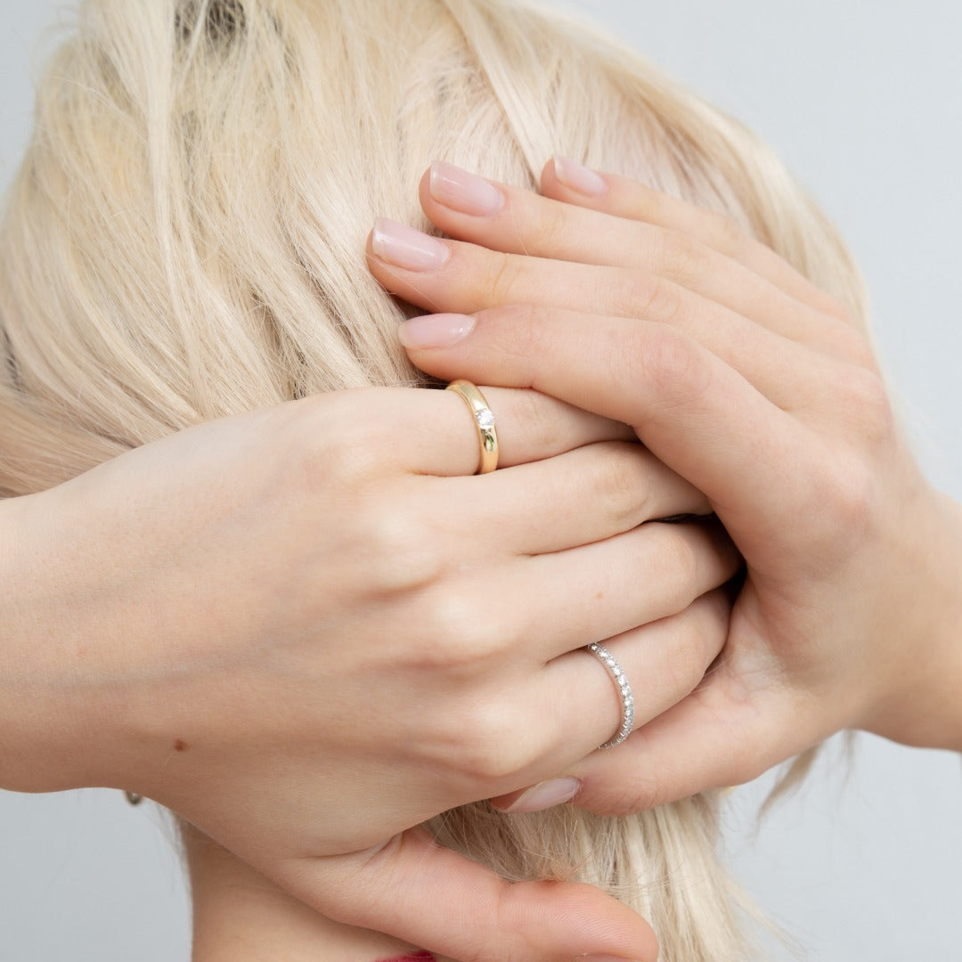 A model wears the Éternité ring on her pointer finger paired with the Talia Pinky Ring. D color, IF/VVS clarity round brilliants held in 2.55 grams of recycled 18k gold for a timeless pavé diamond eternity band totaling ~0.8ct.