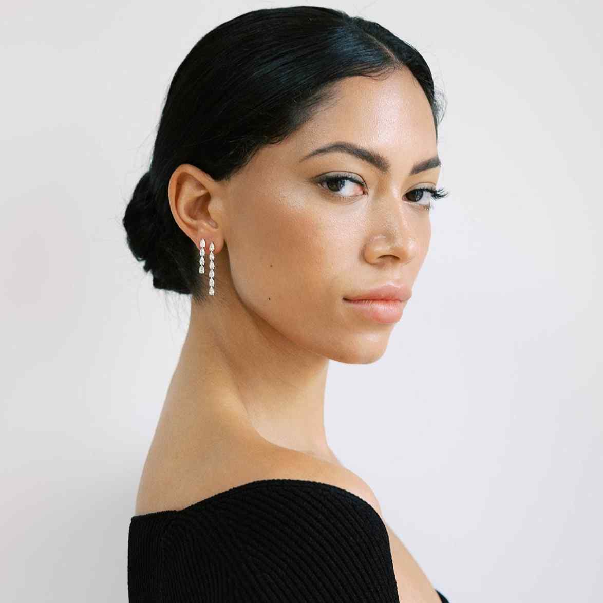 A model wears the Île Column Earring stack - featured on countless Red Carpets globally. The Grande and Petite earrings sit next to each other on the same ear - the most striking earring stack. Both are made with lab-grown, D color, IF/VVS diamonds.