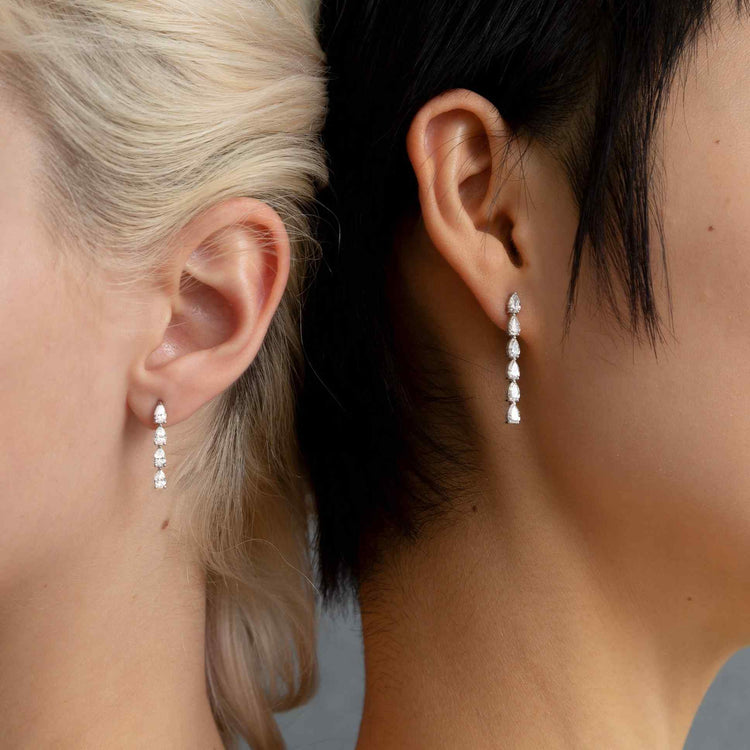 Two models wear the Île Column Earrings - both the Grande and Petite, separately. Whether worn alone, or stacked on the same ear, these earrings shine with D color, IF/VVS clarity diamonds.