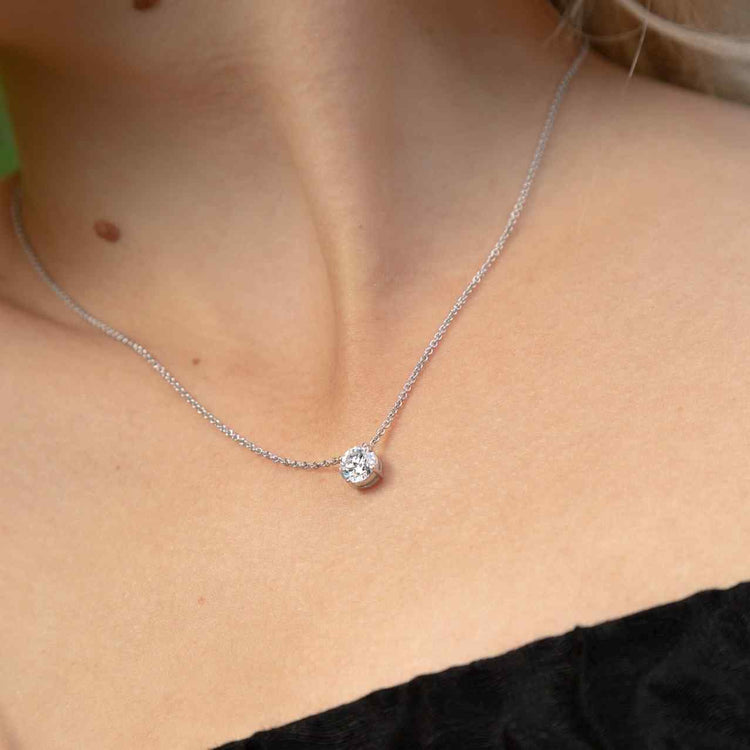 The ultimate timeless necklace. A model wears the Île Round Necklace - a solitaire round brilliant is centered between the collarbone on an 18k White Gold gold chain. The length of this necklace is 16" (40cm). Please get in touch if you would like a different chain length. Shape, color, and size of the diamond are fully customizable as well.