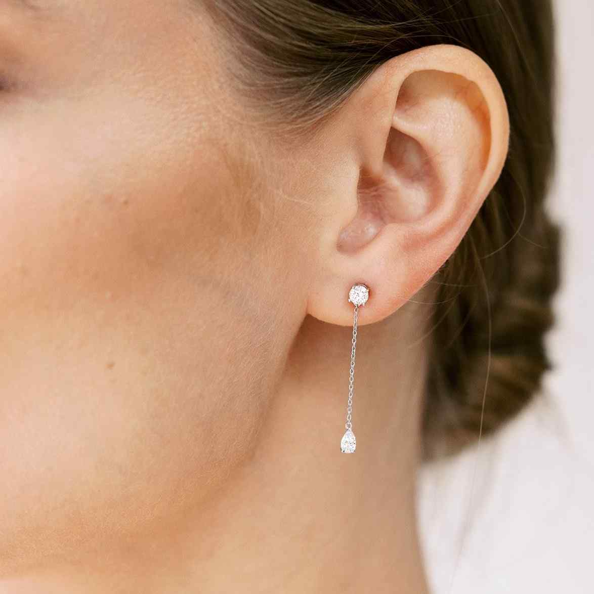 Full of movement, these hanging diamond earrings are strung with a round and pear diamond totaling 0.8 carat and separated by 1 inch of recycled 18k gold. Pair with other pieces in the Lariat collection, Lariat Trois, and the Lariat Necklace. Shown in White Gold here. Sold as a pair.