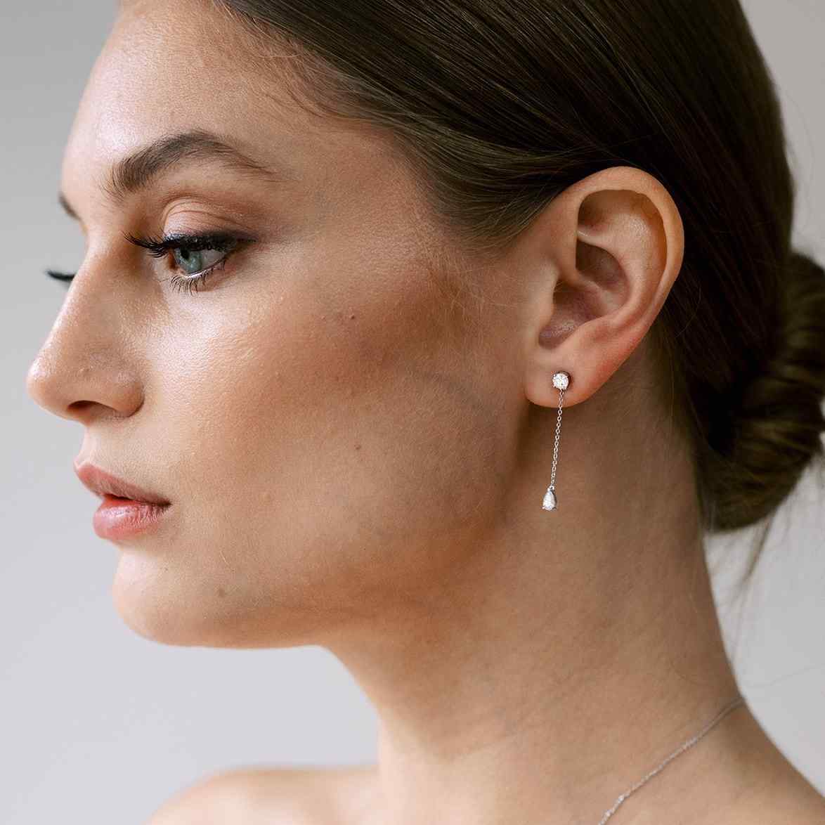 Full of movement, these hanging diamond earrings are strung with a round and pear diamond totaling 0.8 carat and separated by 1 inch of recycled 18k gold. Pair with other pieces in the Lariat collection, Lariat Trois, and the Lariat Necklace. Shown in White Gold here. Sold as a pair.