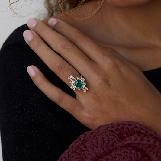 Inspired by the Art Deco period, this inimitable cocktail ring bespeaks the multidimensional and dynamic era. 2 total carat weight of baguette and round diamonds are set in multidimensional space around a recycled 2 carat Emerald. 