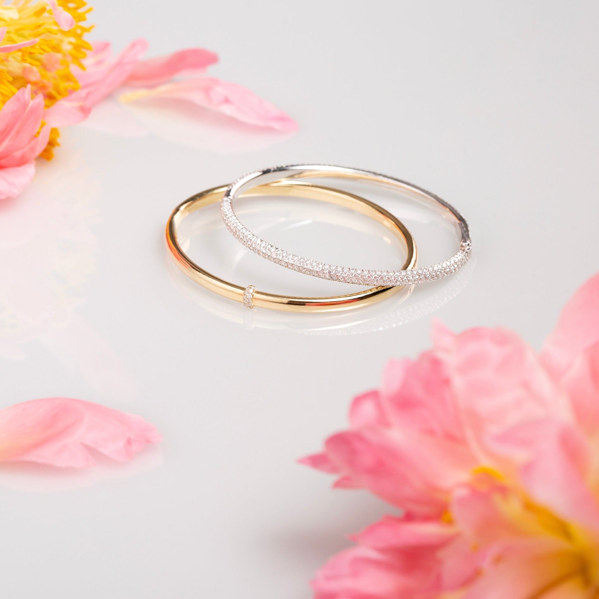 A delicate band of diamonds encircles one point (in the middle) along a 24-gram gold bangle. Shown here paired with the Dalliance Pavé bracelet for a brilliant stack. Our Dalliance Gold bracelet has an inner circumference of 6.3" (16 cm) with a long axis of 2.2" (5.6 cm) and a short axis of 1.8" (4.6 cm). 18k recycled yellow gold shown here.