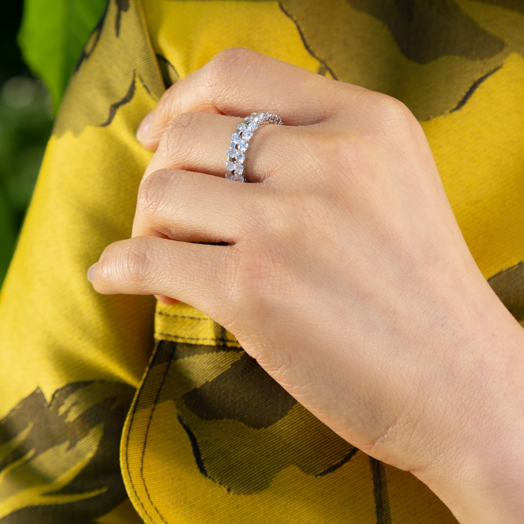 A model wears the Solene Eternity stacked with the Sans Cesse Round Eternity ring on her middle finger - the perfect combination for an elevated day look. Both rings feature D color, IF/VVS clarity diamonds and recycled 18K White Gold.