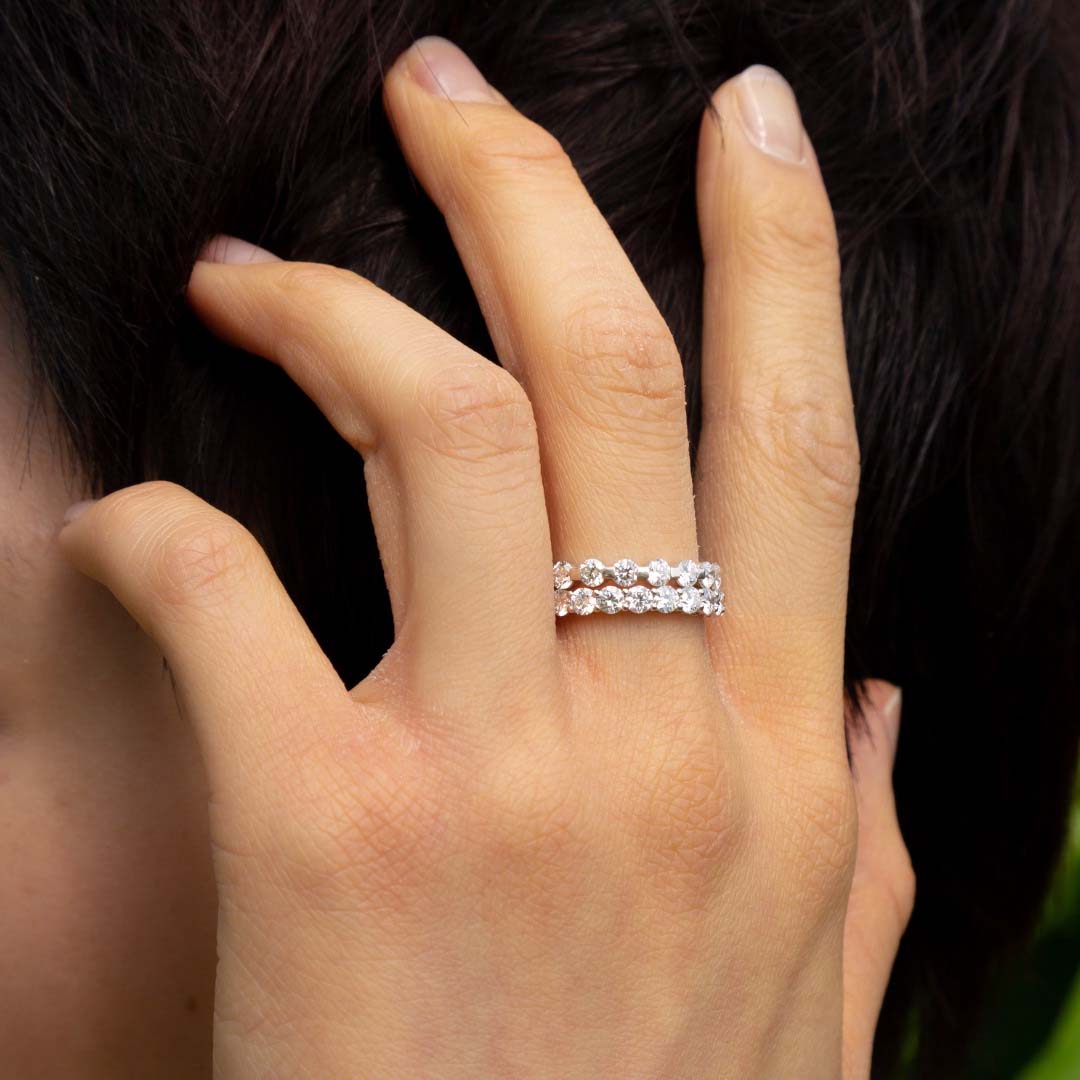 A model wears the Sans Cesse Round Eternity stacked with the Sans Cesse Solene ring on her middle finger - the perfect combination for an elevated day look. Both rings feature D color, IF/VVS clarity diamonds and recycled 18K White Gold.