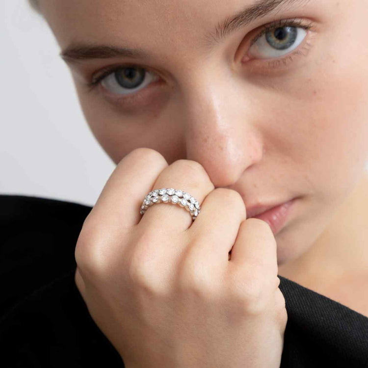 A model wears the Sans Cesse Round Eternity stacked with the Sans Cesse Solene ring on her middle finger - the perfect combination for an elevated evening look. Both rings feature D color, IF/VVS clarity diamonds and recycled 18K White Gold.