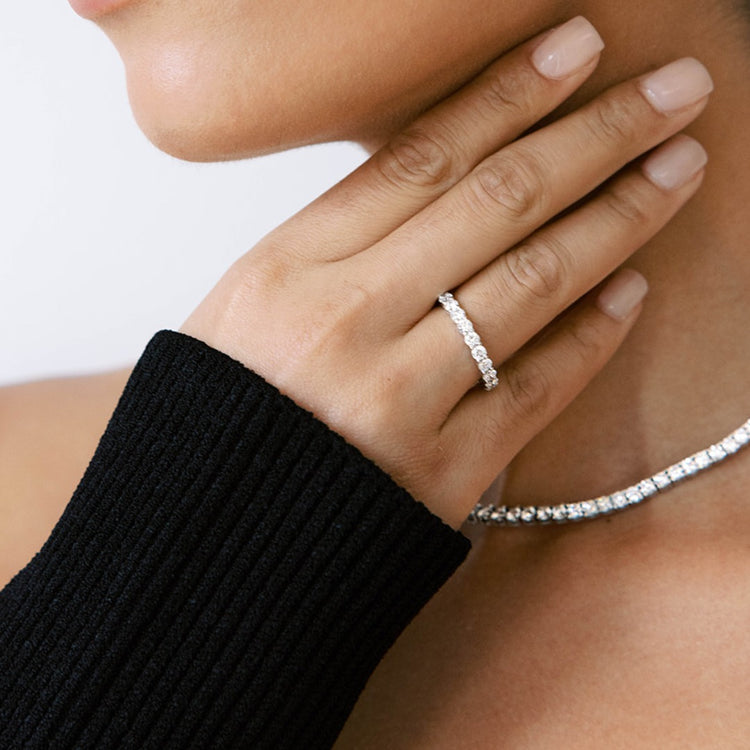 A model wears the Sans Cesse Round Eternity ring paired with the Collier de Diamants Tennis Necklace. Each diamond in the ring is D Color, IF/VVS clarity - set precisely for maximum brilliance and sparkle.